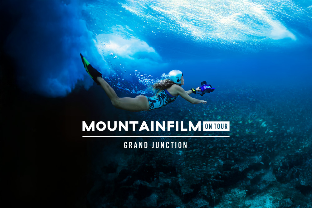 Oceanic photographer Christa Funk swims with her camera underwater. The Mountainfilm on tour - Grand Junction logo is superimposed.