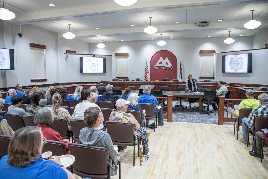 A couple dozen people sit in the audience of the Montrose Budget Open House