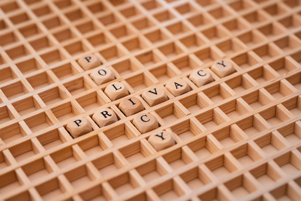 panoramic view to beautiful lake Hopfensee in Bavaria, Germany A Scrabble-like wooden grid has tiles arranged to read, "PRIVACY POLICY."