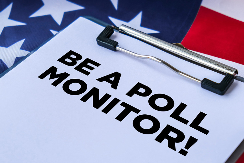 A clipboard holding a paper that reads, "BE A POLL MONITOR!" sits on an American flag