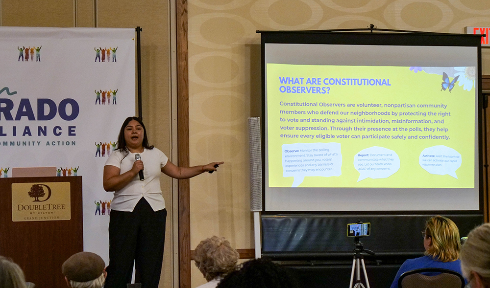 Karime Rodriguez addresses the audience in front of a slide presentation on election protections